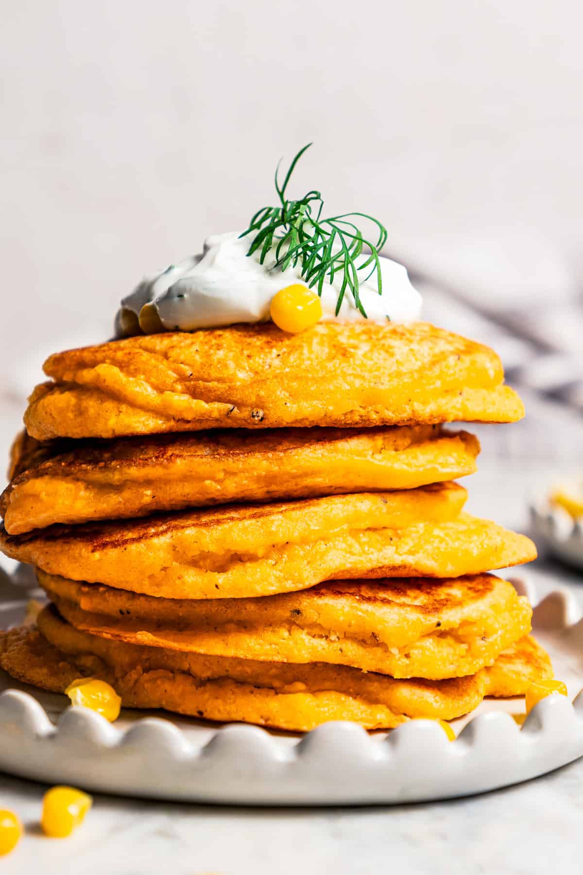 A stack of pancakes topped with creamy yogurt sauce.