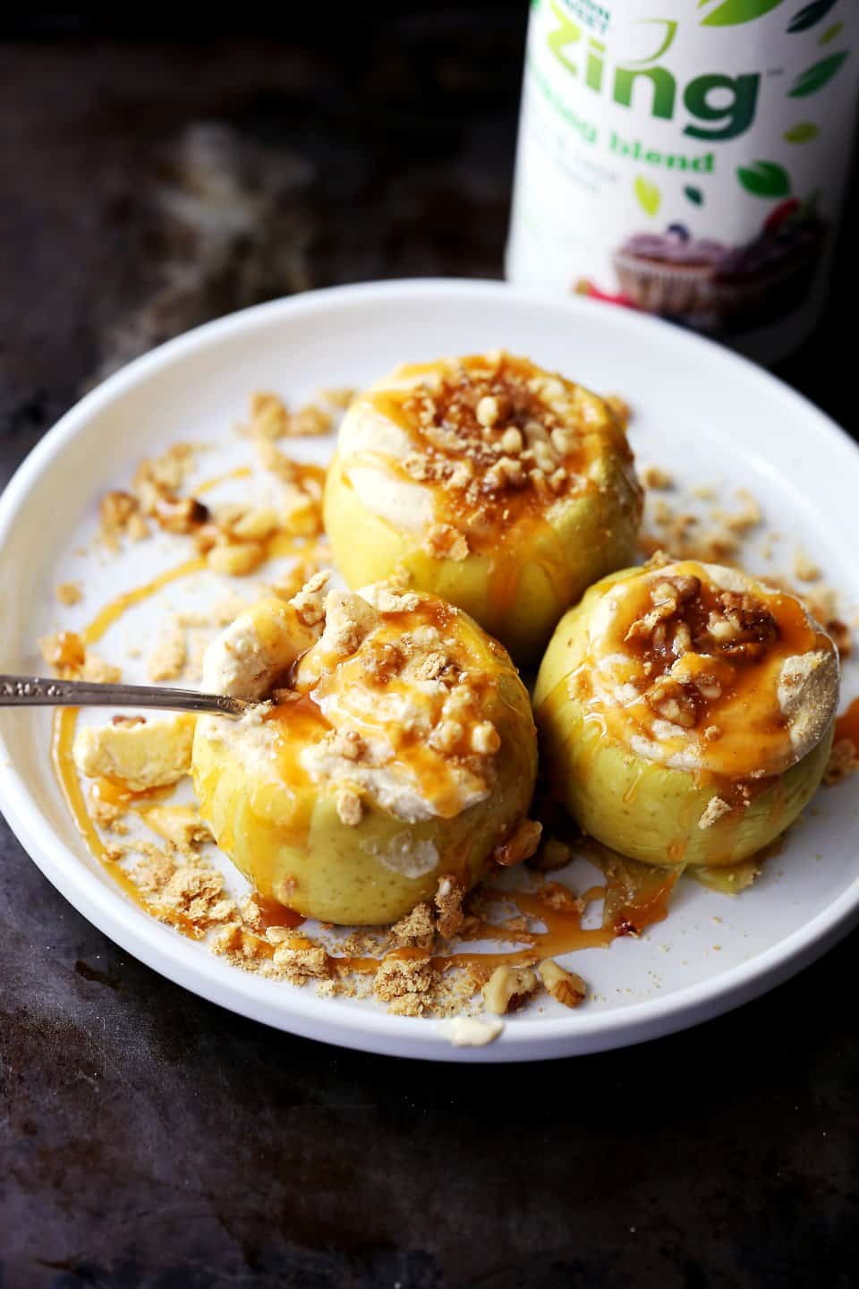 Three cheesecake baked apples with caramel sauce and a can of Zing in the background
