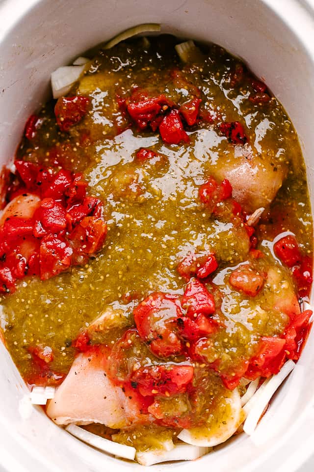 salsa verde poured over chicken breasts in a slow cooker