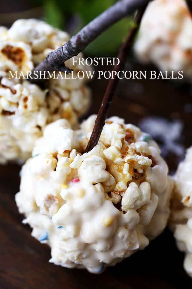 Frosted Marshmallow Popcorn Balls - Held together with a mixture of melted marshmallows and butter, and dipped in Frosting, these Marshmallow Popcorn Balls make great treats for kids, especially around Halloween!