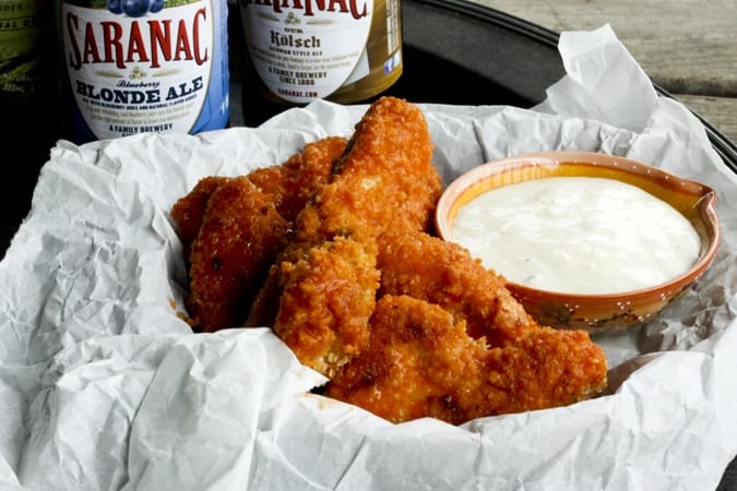 Oven-fried Homemade Chicken Nuggets and Boneless Buffalo Wings in a paper-lined basket with dipping sauce
