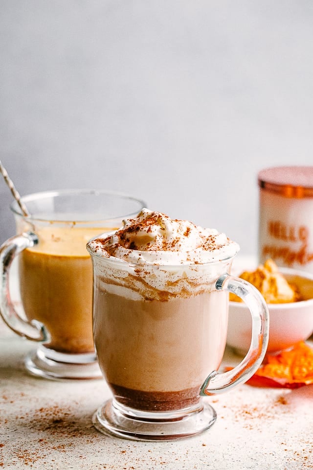 pumpkin spice latte in a mug with whipped cream on top.