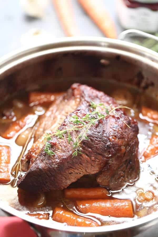 Sweet and Savory Braised Brisket in a skillet with baby carrots