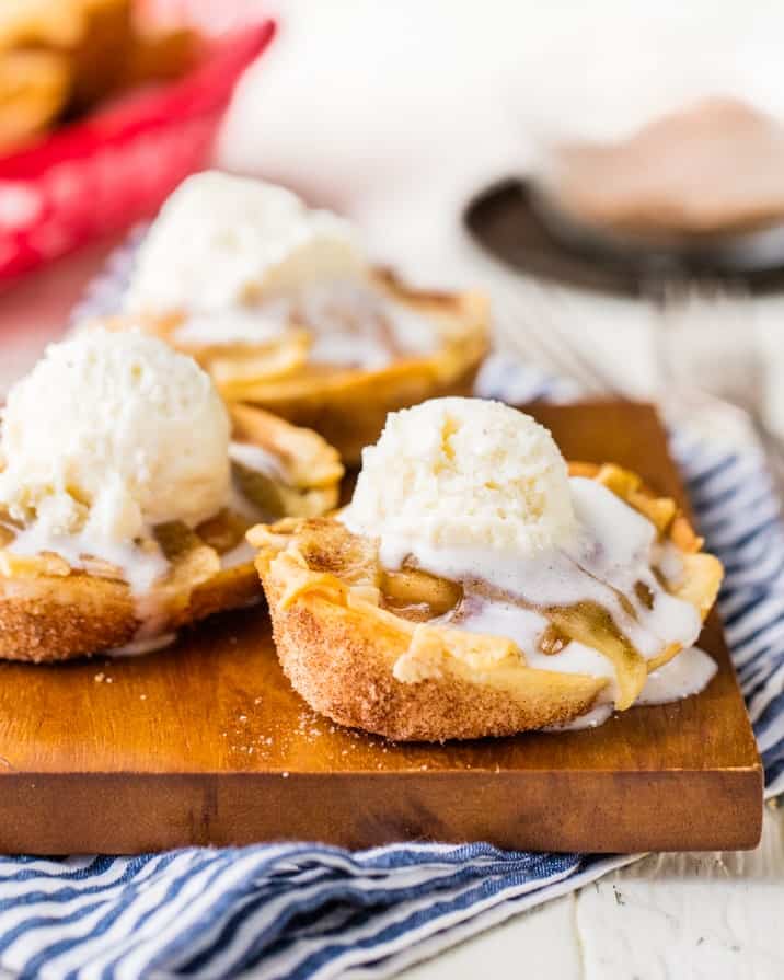 3 Apple Pie Taco Boats with ice cream on a wooden board