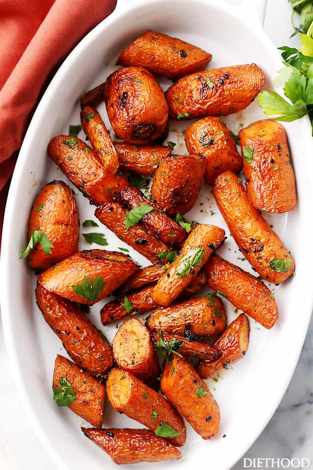 Overhead image of garlic butter roasted carrots placed in a white dish.