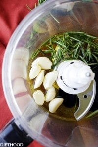 Seven cloves of garlic, some rosemary, olive oil and balsamic vinegar in a food processor ready to be mixed