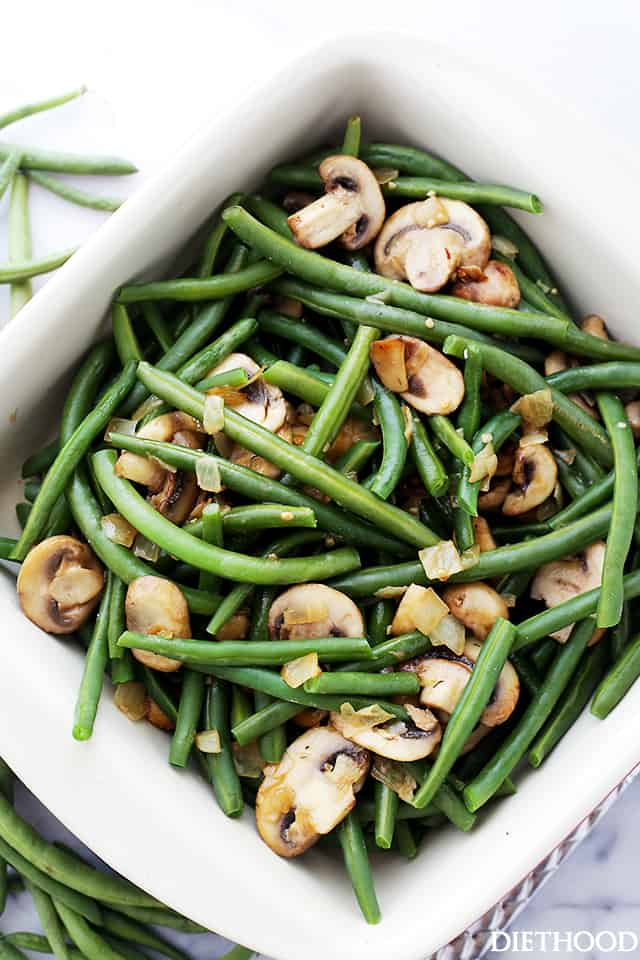 Cooked green beans and mushrooms combined in a baking dish.