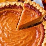 Lifting a slice of pumpkin pie with a server.