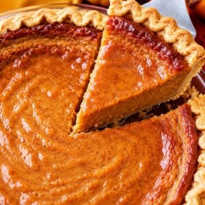 Lifting a slice of pumpkin pie with a server.
