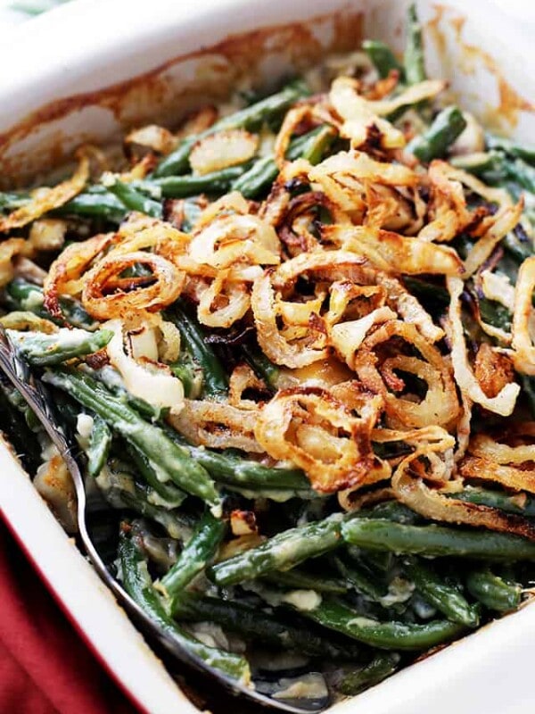 Vegan green bean casserole topped with crispy onions in a casserole dish.