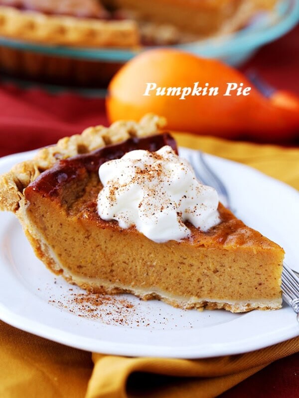 A slice of Healthy Pumpkin Pie that's rich, creamy, and topped with low-fat whipped cream. The ultimate Thanksgiving dessert!