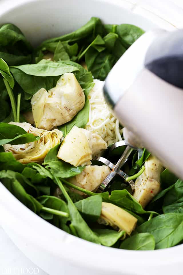 Image of baby spinach and artichokes in a white ceramic pot.