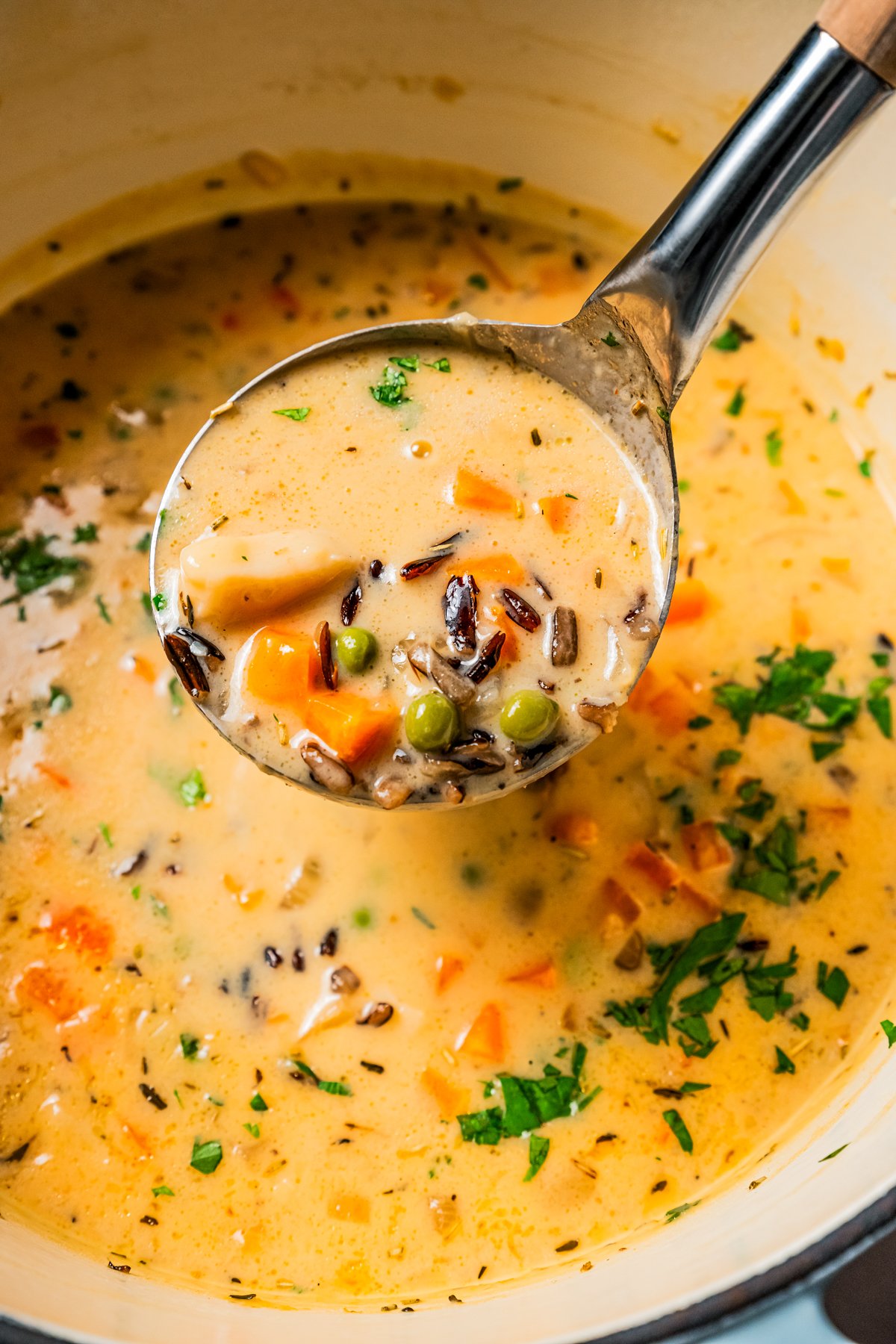 A ladle scooping crab soup from a pot.