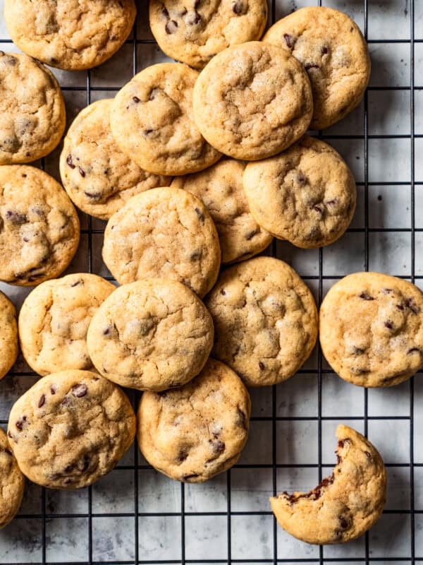 Assorted mini chocolate chip cookies on a wire rack.