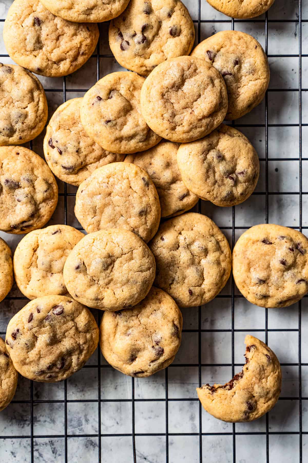 Assorted mini chocolate chip cookies on a wire rack.