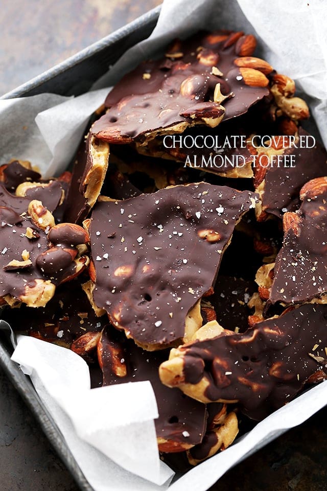 Pieces of Chocolate Covered Almond Toffee piled in a container 