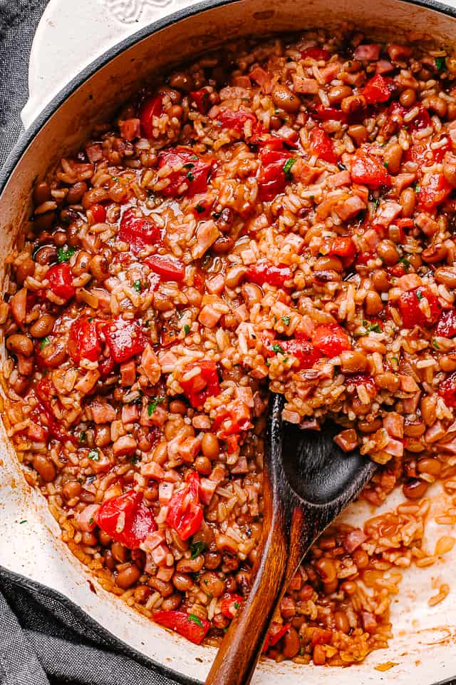 A wood spoon scooping out Hoppin' John rice