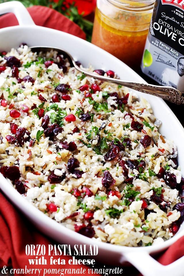 Orzo Pasta Salad with Feta Cheese and Cranberry Pomegranate Vinaigrette served in a white oval dish.