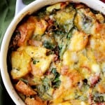 Make ahead breakfast casserole topped with broiled cheese in a white baking dish.