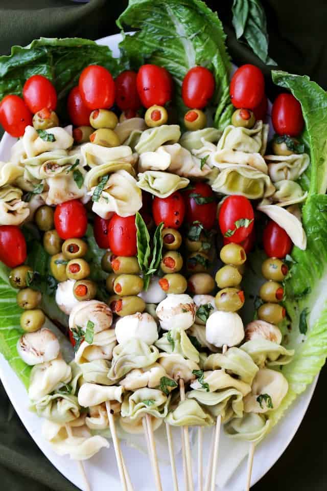 Tortellini Skewers with Olives Tomatoes and Cheese Recipe - Fun and festive appetizer plate with cheesy tortellini, flavorful manzanilla olives, grape tomatoes and fresh mozzarella cheese threaded on skewers. A gorgeous addition to your Holiday table!