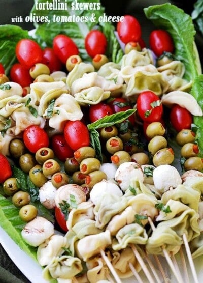Tortellini Skewers with Olives Tomatoes and Cheese Recipe - Fun and festive appetizer plate with cheesy tortellini, flavorful manzanilla olives, grape tomatoes and fresh mozzarella cheese threaded on skewers. A gorgeous addition to your Holiday table!