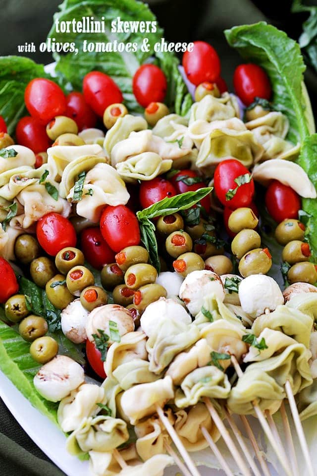 Tortellini Skewers with Olives Tomatoes and Cheese Recipe - Fun and festive appetizer plate with cheesy tortellini, flavorful manzanilla olives, grape tomatoes and fresh mozzarella cheese threaded on skewers. A gorgeous addition to your Holiday table!