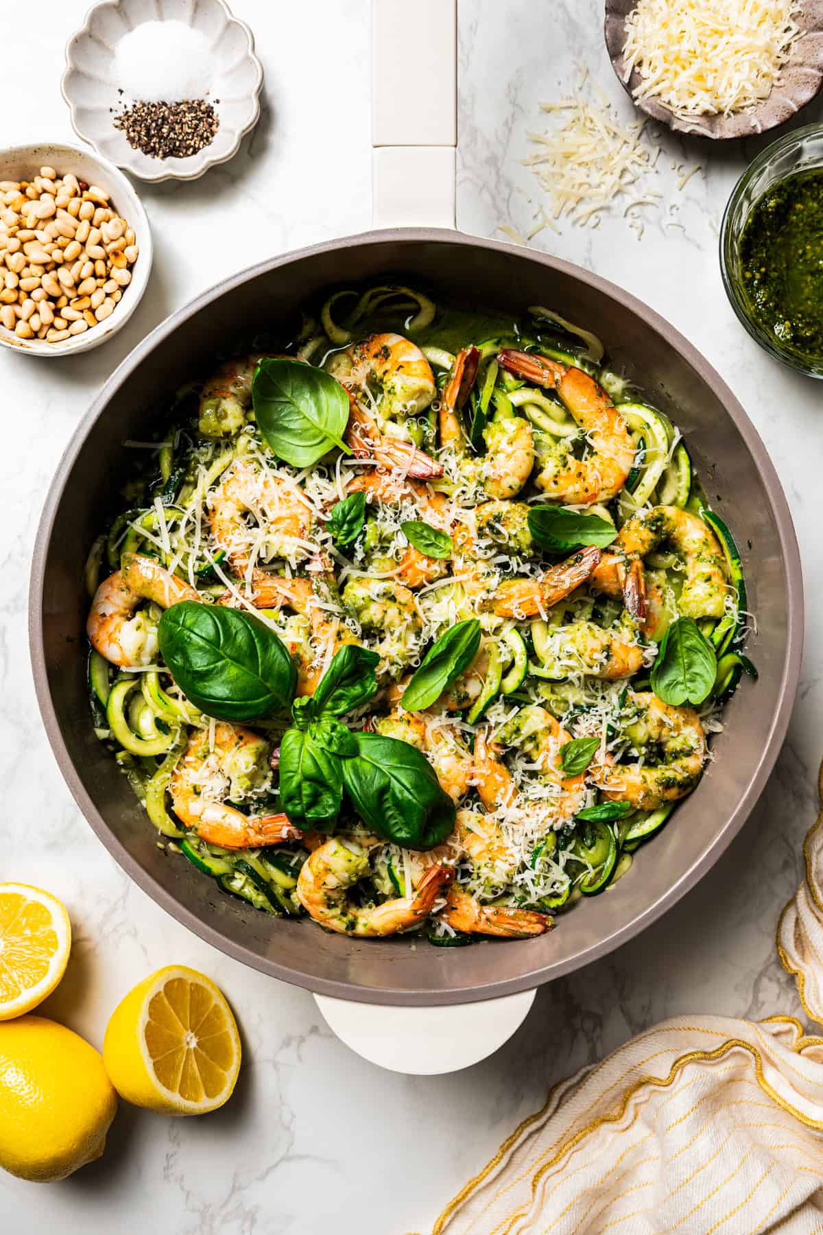 Pesto zoodles and shrimp in a skillet.