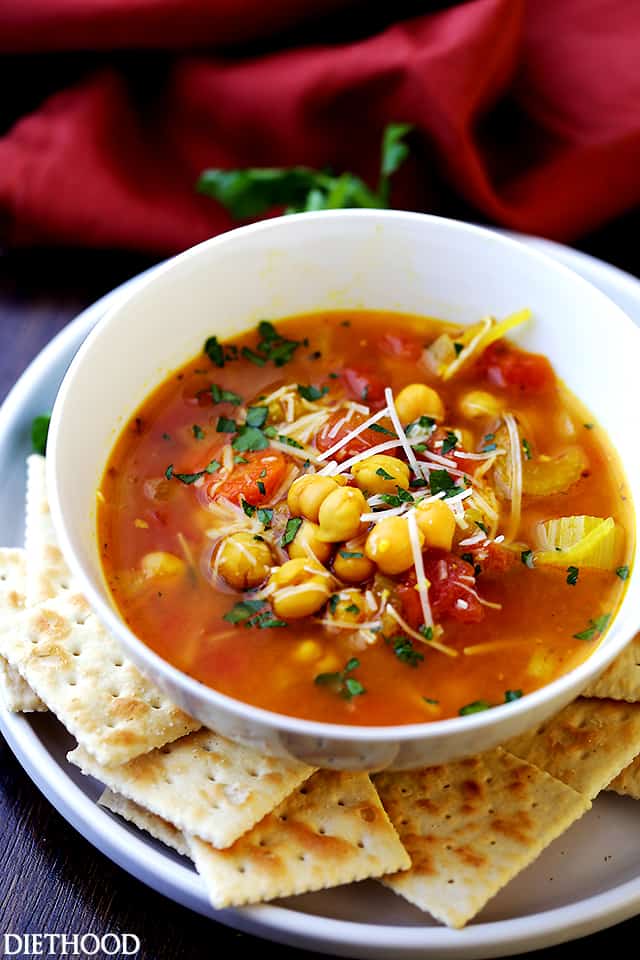 Chickpea Vegetable Soup in a soup bowl, and saltine crackers arranged around the bowl.