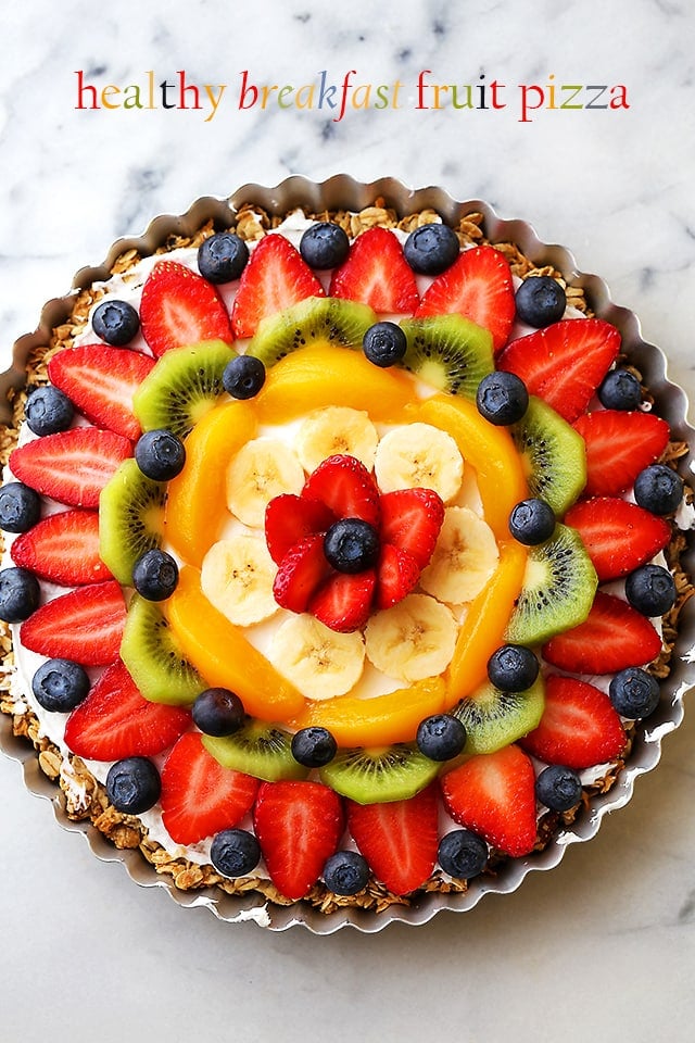 Overhead shot of a fruit pizza topped with berries, bananas, kiwi, and peaches.