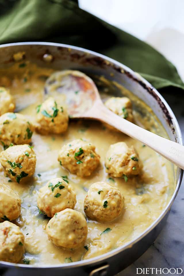 Angled photo of baked meatballs in the pan with gravy. 