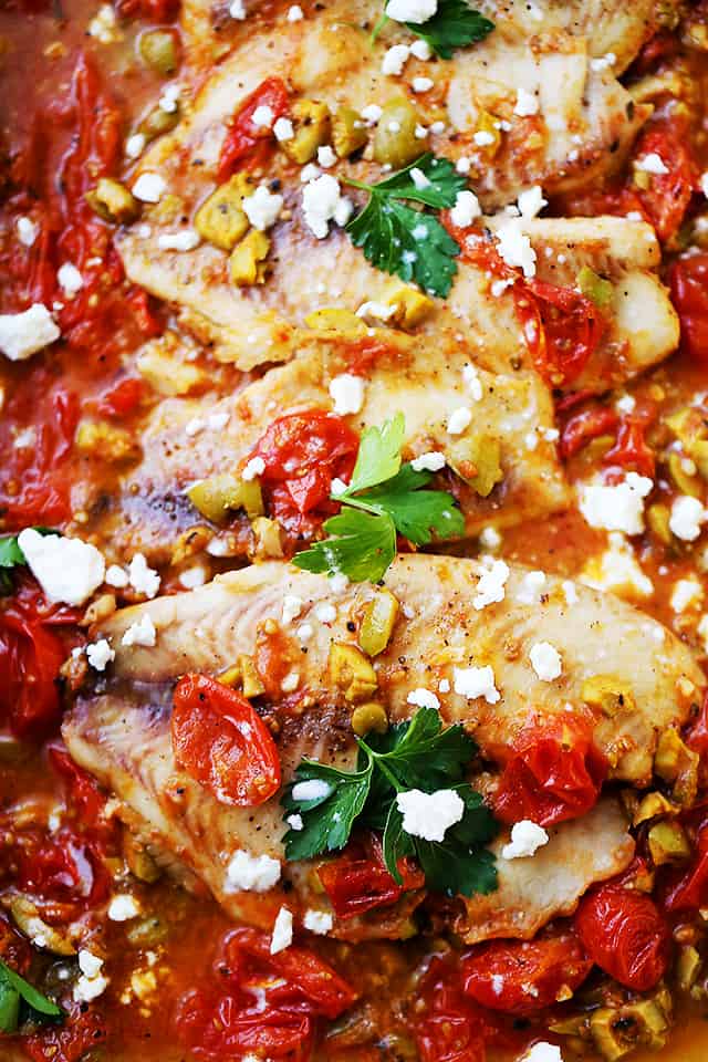 Close-up photo of cooked fish filets topped with crumbled feta cheese.