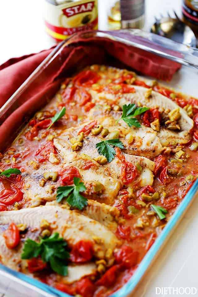 A baking dish with talapia fillets cooked in tomato sauce.