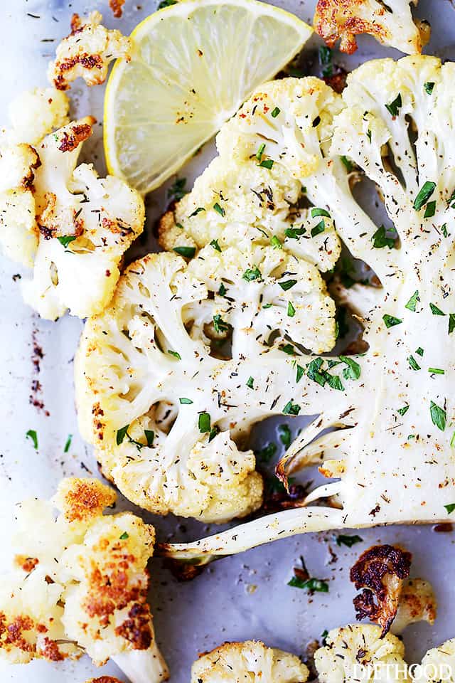 Make crispy roasted cauliflower tossed in olive oil and seasoned with lemon zest, paprika, and thyme. An easy, flavorful vegetable side dish! Overhead view of roasted cauliflower seasoned with lemon, paprika, and thyme on a baking sheet.