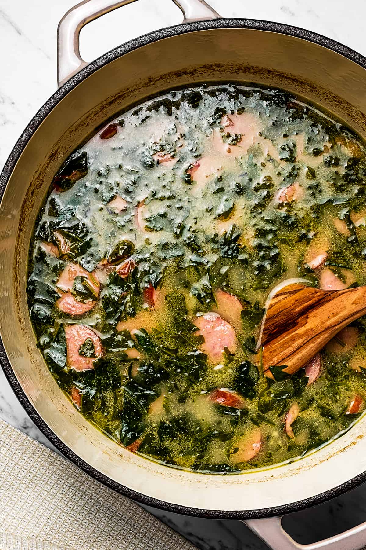 A pot of sausage, kale, and potato soup.
