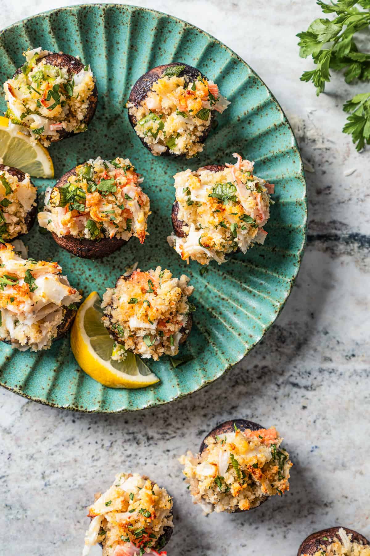 Stuffed mushrooms served on a green stoneware plate.