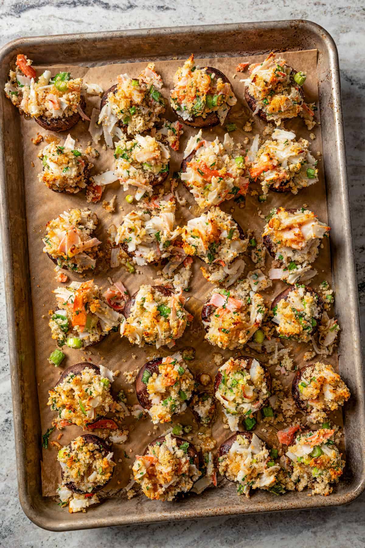 Baked crab stuffed mushrooms on a baking sheet.