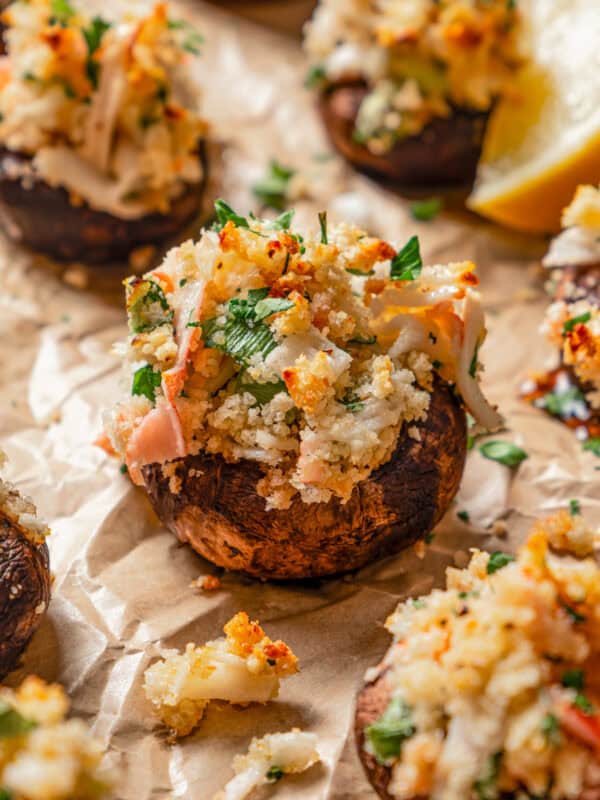 Close-up of crab stuffed mushrooms on a baking sheet.