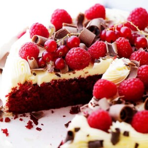 Red Velvet Cake set on a cake plate with one slice missing from it to expose the interior of the cake.