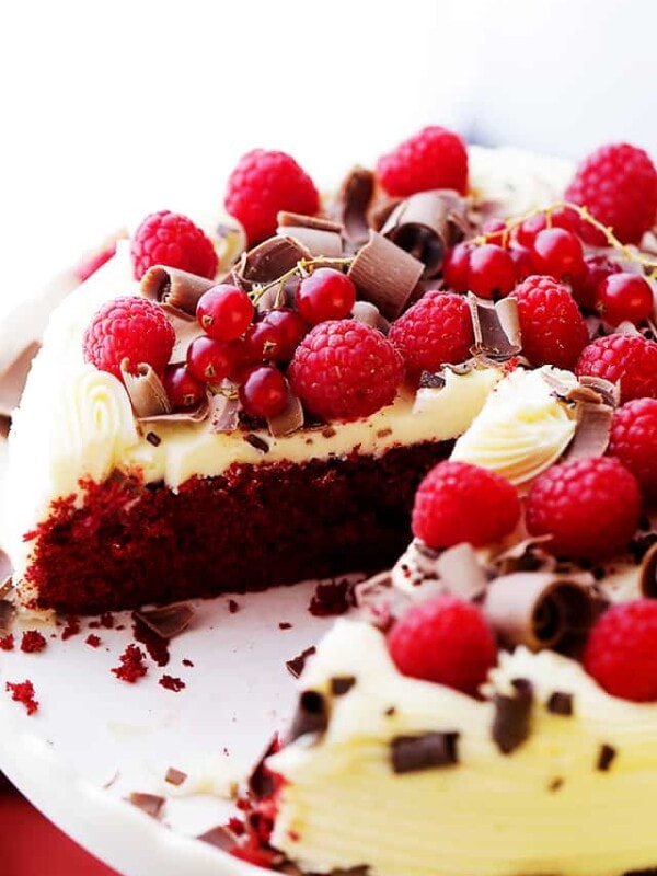 Red Velvet Cake set on a cake plate with one slice missing from it to expose the interior of the cake.