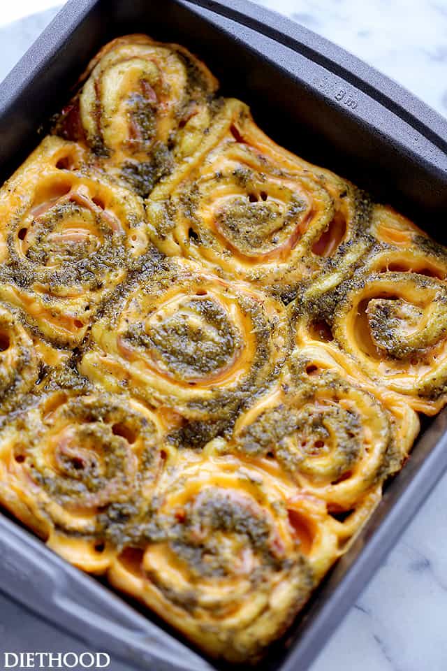 Pesto Ham and Cheese Rollups baked in a pan.