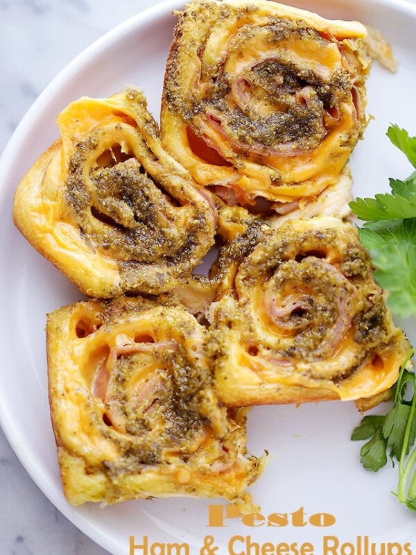 Pesto Ham and Cheese Rollups Recipe - Quick, delicious, easy party food with refrigerated crescents dough, ham, cheese and basil pesto. You're only 4 ingredients away from your next favorite bite!