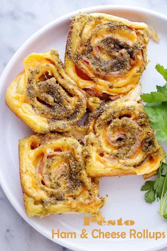Pesto Ham and Cheese Rollups Recipe - Quick, delicious, easy party food with refrigerated crescents dough, ham, cheese and basil pesto. You're only 4 ingredients away from your next favorite bite!