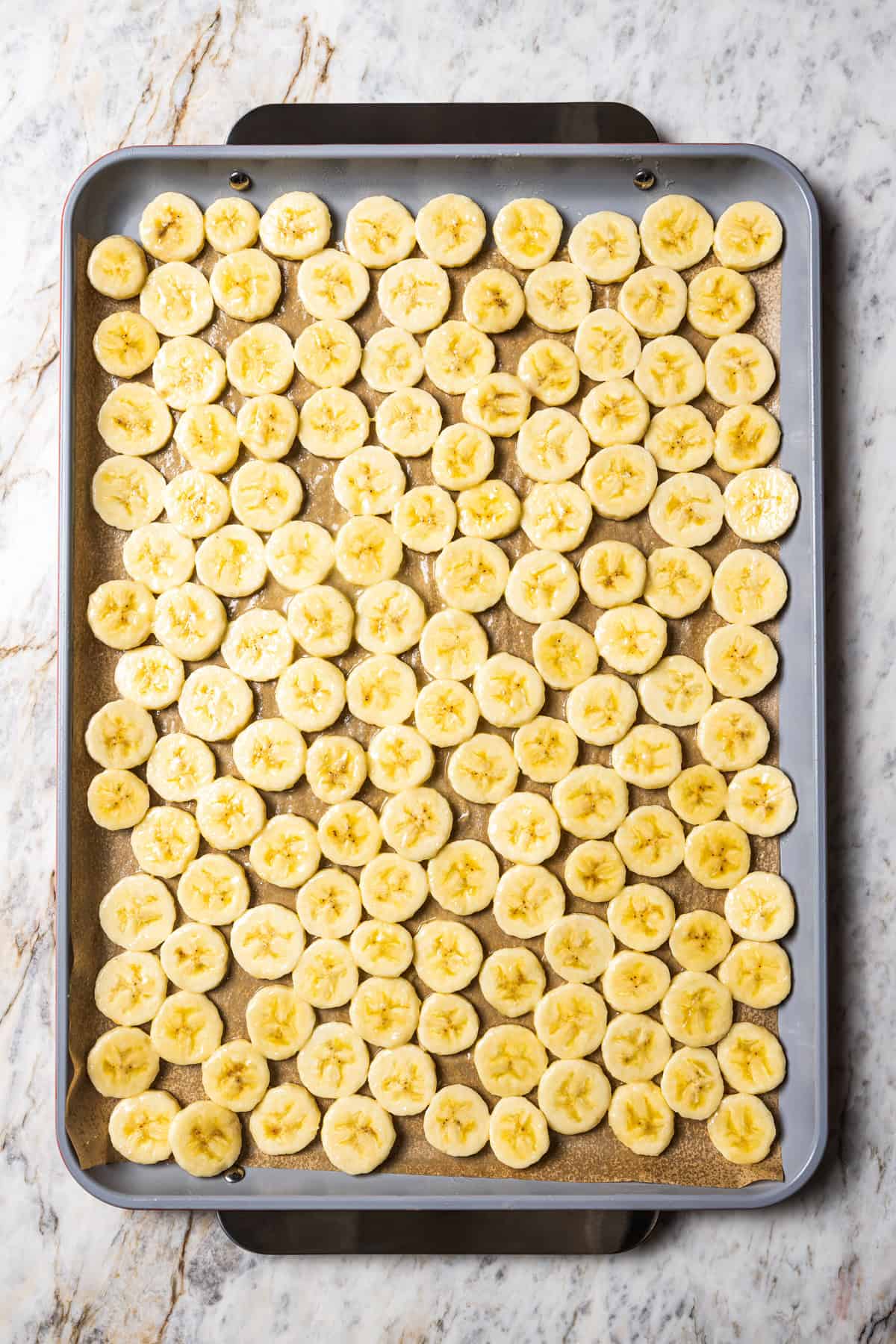 Banana slices on a large baking sheet.