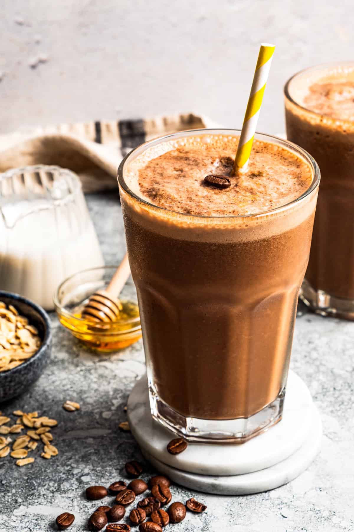 Coffee smoothie in a drinking glass with a straw.