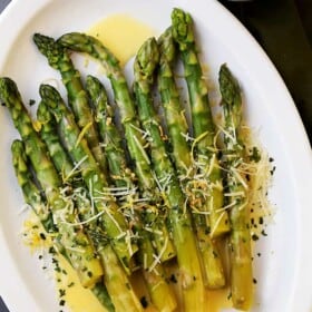 Asparagus with Lemon Butter Sauce – Budget friendly, quick, and easy crisp-tender asparagus drizzled with an amazing lemon butter sauce and a sprinkle of parmesan cheese. The BEST asparagus side dish of ever!