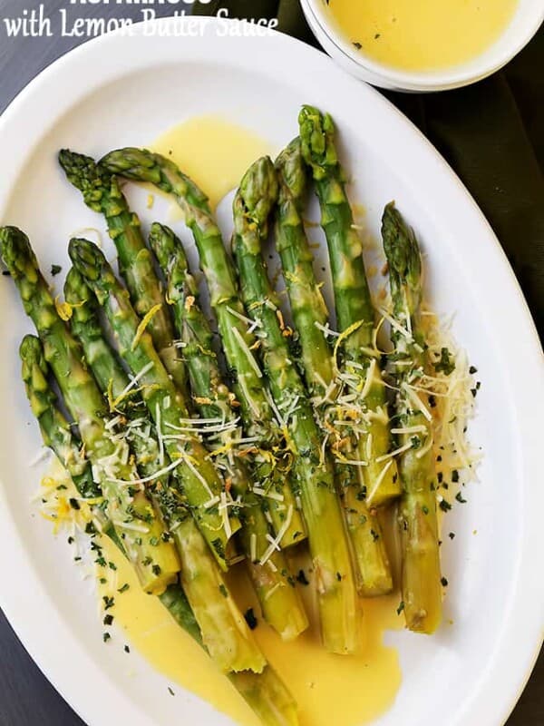 Asparagus with Lemon Butter Sauce – Budget friendly, quick, and easy crisp-tender asparagus drizzled with an amazing lemon butter sauce and a sprinkle of parmesan cheese. The BEST asparagus side dish of ever!