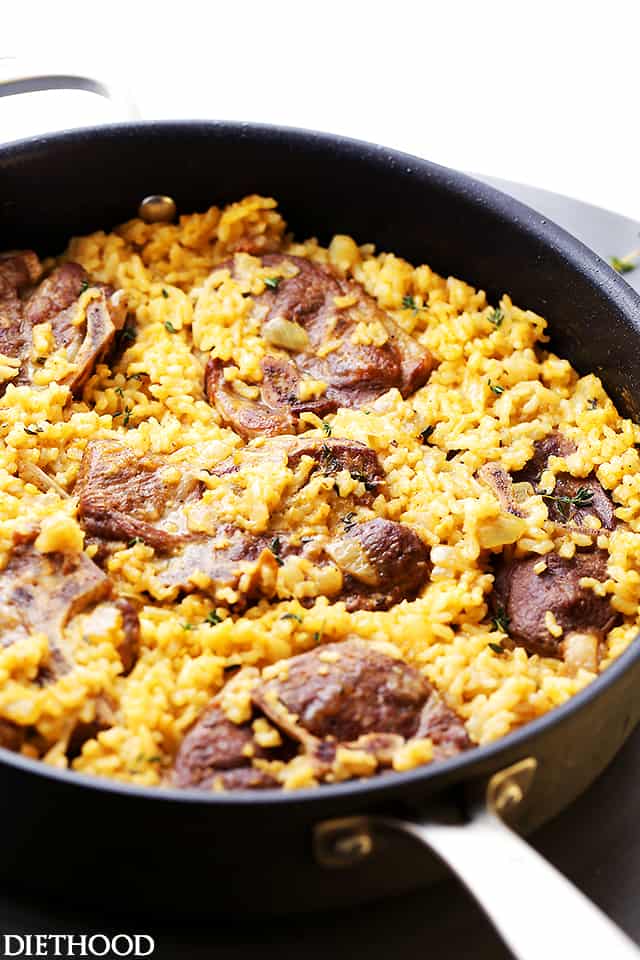 Baked lamb chops and risotto cooking in a skillet.