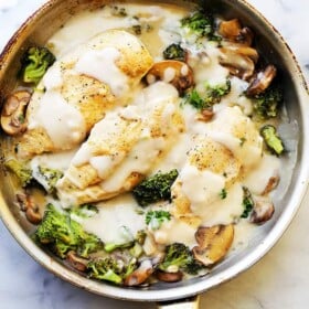 Creamy chicken Alfredo with broccoli in a skillet.