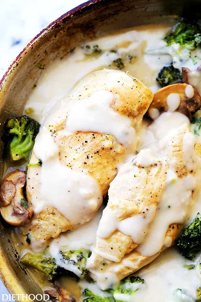 A close up of creamy chicken Alfredo with broccoli in a skillet.