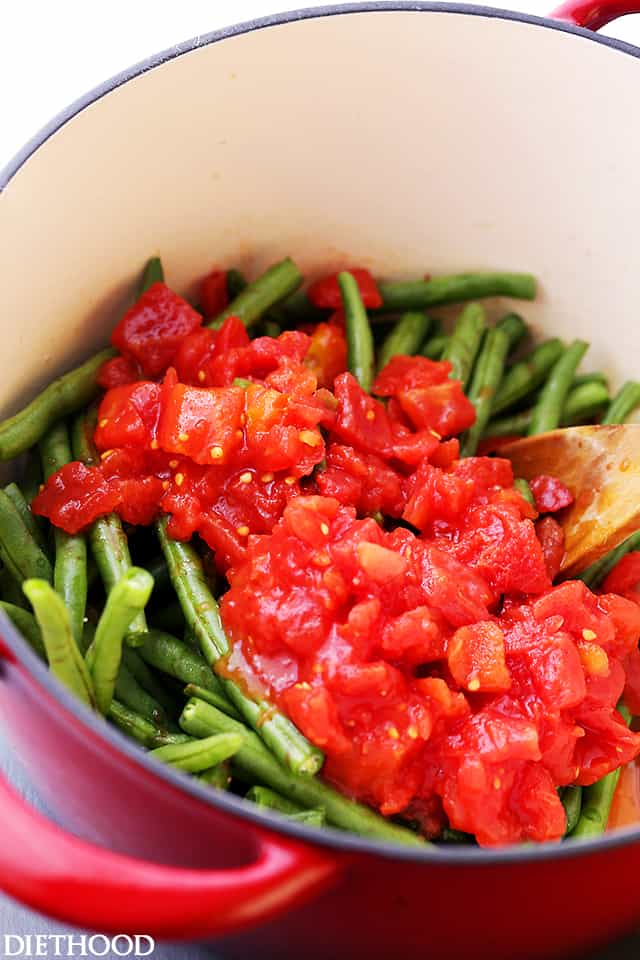 Fresh green beans with diced tomatoes in a pot to be cooked